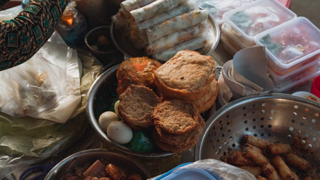 A vibrant assortment of Vietnamese street food at a market in Bình Thuận, showcasing traditional snacks.